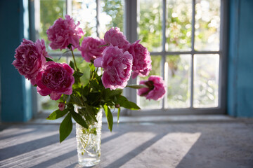 table with a bouquet of flowers. A sunny summer day. Window in the background.