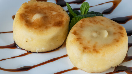 Tasty cheese pancakes with caramel sauce, powdered sugar and mint. Cottage cheese pancakes for Breakfast or lunch.