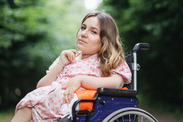 Portrait of young caucasian woman with disability in stylish summer dress looking at camera with...