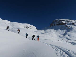 Fototapeta na wymiar Ski de randonnée alpinisme dans les montagnes des Alpes l'hiver dans la neige avec un groupe de skieurs aguerris