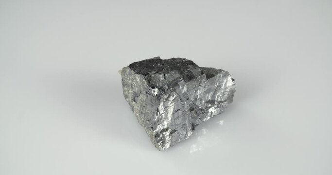 Rotation galena mineral on a white background. Lead ore.