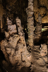 Stalactites with a polished structure at the entrance of the Nerja cave. Selective focus on the nearby formation.