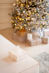Gift box on background of New Years bokeh lights of Christmas tree.Copy space. Soft selective focus.