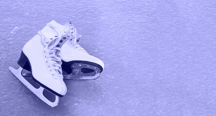 old white figure skates lie on ice in the color of the year 2022 very peri , winter outdoor activities, sports health in winter, space for text