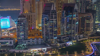 Dubai Marina skyscrapers and JBR district with luxury buildings and resorts aerial night timelapse