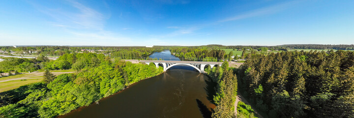 Naklejka premium Summer panoramic aerial view of bridge and Kymijoki river waters in Finland, Kymenlaakso, Kouvola, Koria