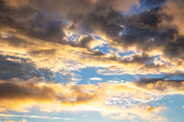 Colorful sky at dawn with dense clouds against a background of blue sky