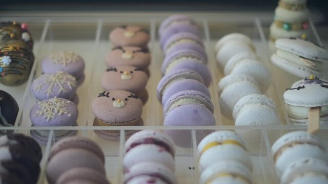 Assortment of french macaroons decorated for Christmas on the shelf in patisserie cafe, delicious enjoyment on Xmas holidays.