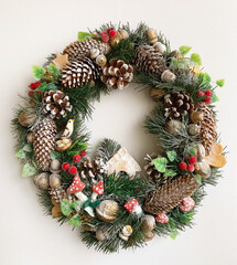 Christmas wreath on the door.  Interior decor.  New Year's decor.  On white background.  Isolate.  Present.  moreover, a nest, gingerbread hearts, a house, berries, cones, fly agarics.