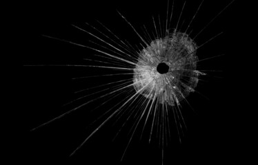 Obraz premium a crack on a broken glass mirror on a black background lines fragments bullet hole