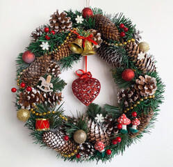 Christmas wreath on the door. New Year's decor. Bright festive. Bells and a red heart in the middle. Sequins. For the interior.