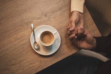 Valentine's celebration. a detail of two hands touching on a table.overhead view.copyspace.