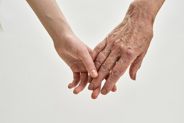 Grandma and young girl holding hands each other