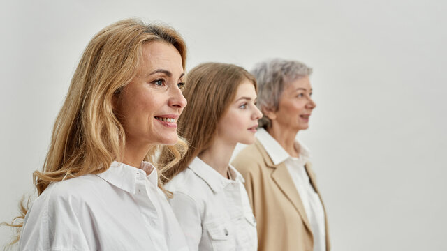 Three female generations standing and looking away