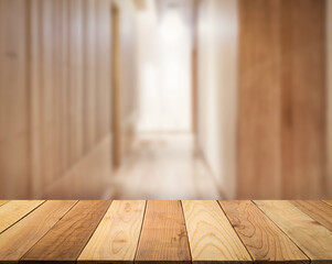 Empty wooden table top with blur image of a corridor in the hotel or bar interior nature wood lobby in the perspective background, copy space for your text ready for product promotion display montage