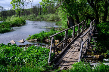 Fototapeta premium Wooden bridge over the Titva river near the village of Yartsevo. Bridge to the other side