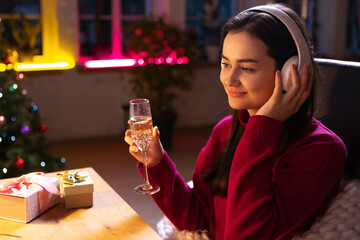 Online celebration and Christmas holidays during quarantine life. Beautiful young girl talking with friends by means of video communication