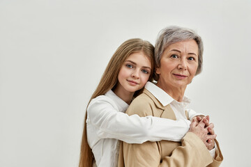 Granddaughter hug her grandma on white background