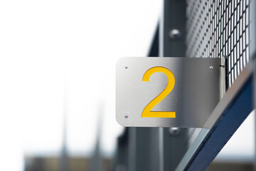Marking of a track with the number two in yellow, number two on a metal sign