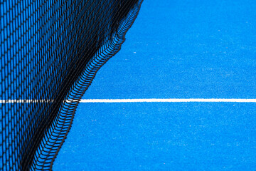 The net and the white line, medium in a blue paddle court