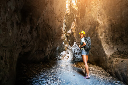 Happy alone woman wearing helmet for safety is engaged in active canyoning and hiking along the Saklikent Gorge in Turkey. New experience and outdoor leisure recreation