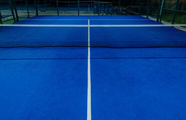 Blue paddle tennis court at night