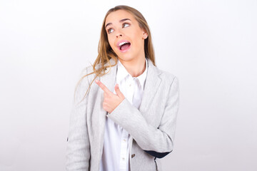 Young business woman wearing jacket over white background glad cheery demonstrating copy space look novelty