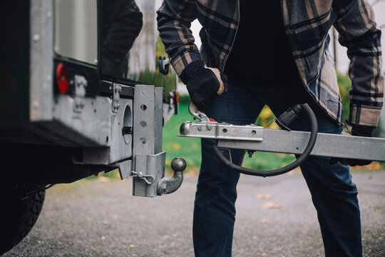 Midsection of man towing trailer at driveway