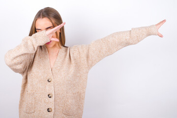Photo of funky  young caucasian girl wearing knitted sweater over white background show disco move...