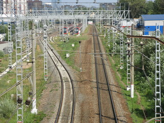 suburban railway tracks with poles and rails in summer
