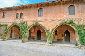Grazzano-Visconti medieval building with three arches covered with plants. Italy, Piacenza, Emilia-Romagna