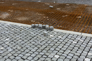 street paved with setts, visible gaps, steel reinforcing, reinforcing mesh fabric.