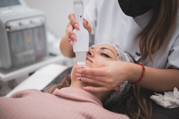 Obraz na płótnie Canvas Hydrofacial machine Facial cavitation procedure. Beauty salon treatment. Electric spa equipment. Medicine patient device. Acne removal.