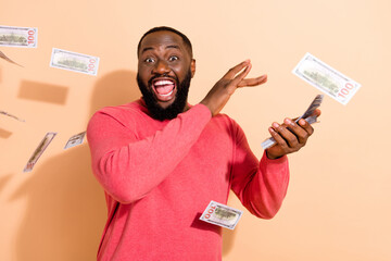 Photo of hooray young brunette guy spend money wear pink sweater isolated on beige color background
