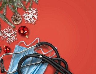 Christmas banner with festive decorations, medical stethoscope and facial masks on red background.
