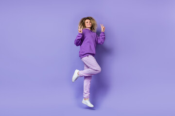 Fototapeta na wymiar Photo of adorable pretty lady dressed hoodie humping high showing v-signs isolated purple color background