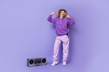 Photo of funny pretty lady dressed hoodie walking dancing enjoying music isolated purple color...