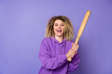 Photo of funky excited lady dressed hoodie laughing holding baseball beat isolated purple color background