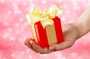 Female hand holding Christmas gift boxes. Holiday sale concept.