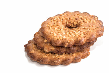 Shortcrust pastry biscuits with crushed peanuts in a ring on an isolated white background.