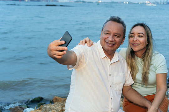 Couple in their fifties taking a selfie with their cell phone