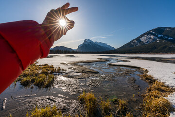 Catching sun winter sunrise over frozen Vermilion Lakes in Banff National