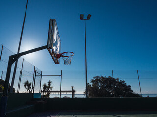 Shadow of outdoor basketball net with blue sky during summer