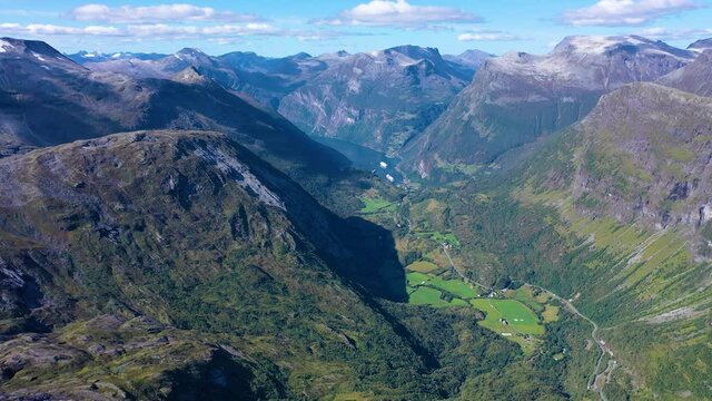 Breath taking view of mountain peaks and green valley and a lake in geiranger fjord in Norway