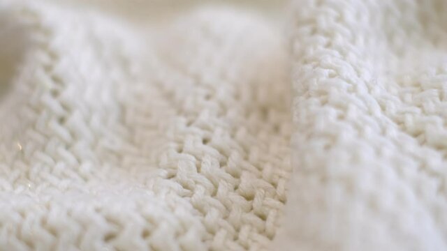 closeup the motion footage vide. Textile abstract background. Clothing industry concept. Wavy clean material. Fibers of knitted clothes with white threads. Knitted fabric threads macro.