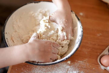 The child's hands prepare the dough