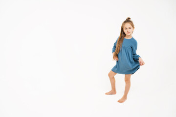 Cute little girl in a blue dress. A place for text and advertising. A beautiful child with long...
