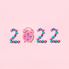 The creative minimal idea for New Year's Eve 2022 with a clock and ornaments in pastel pink and blue color.