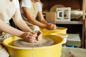 Hands of a potter. Potter making ceramic pot on the pottery wheel