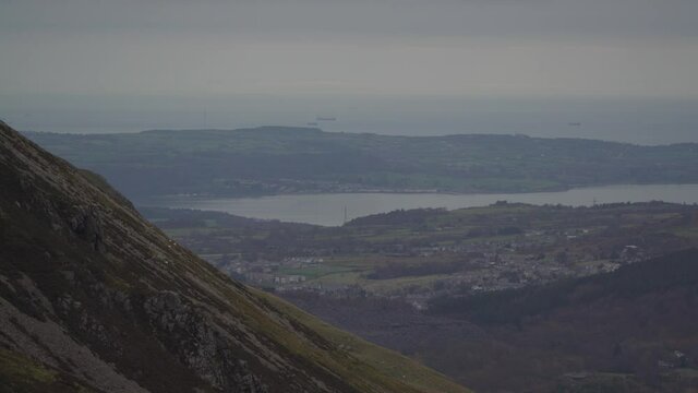 Aerial view of Anglesey with Snowdonia mountains foreground and boats 